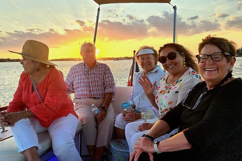 A group of people on a boat during sunset. 4