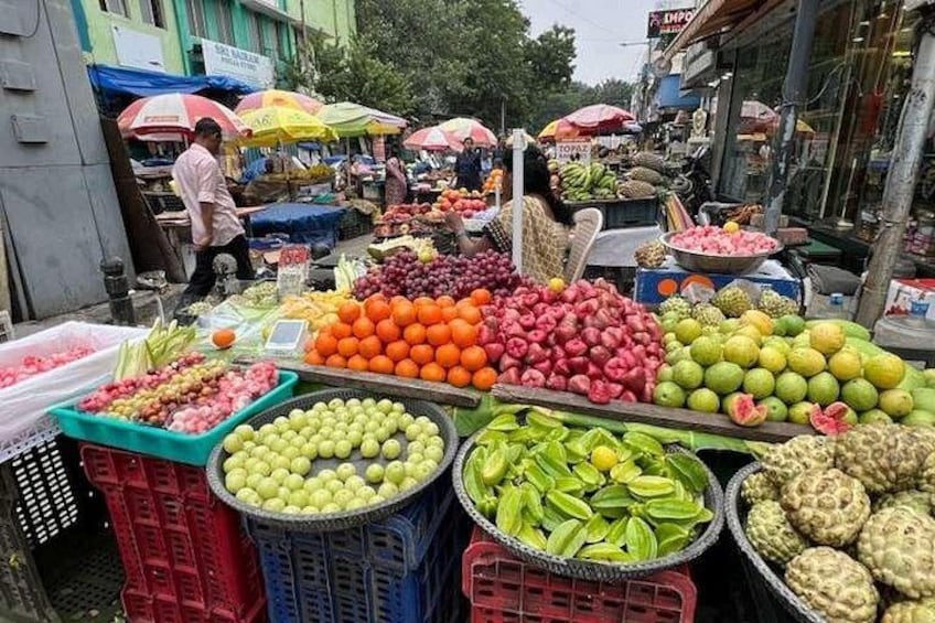 A bustling outdoor market with various fruits and vegetables displayed in crates and baskets. 5