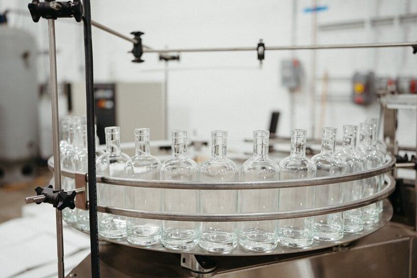 Un'ambiente di laboratorio con un supporto circolare che contiene diverse bottiglie di vetro trasparenti. 4