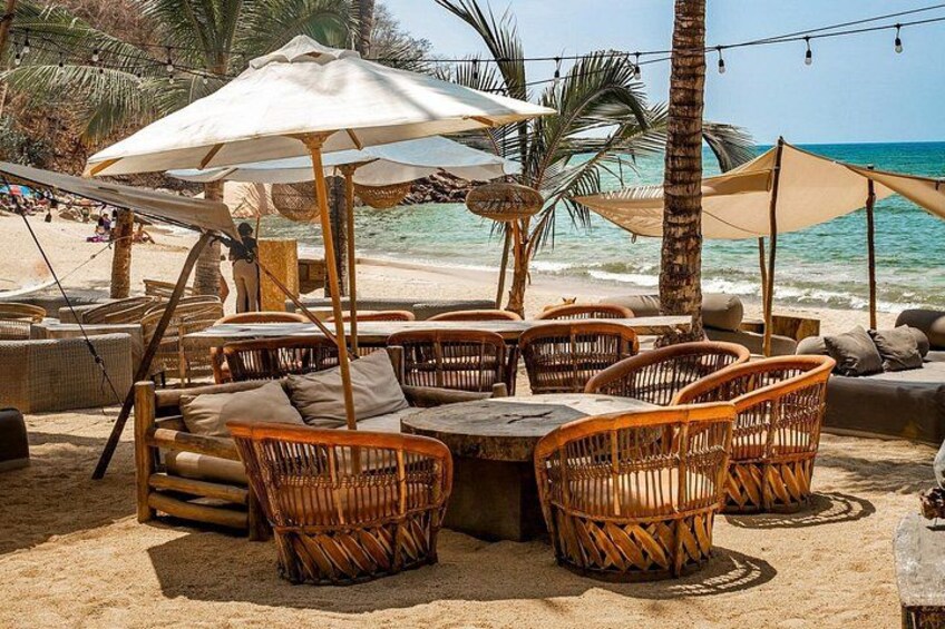 Un caffè sulla spiaggia con mobili in vimini e ombrelloni. 2
