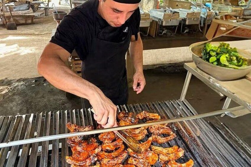 Una persona cucina carne su una griglia da esterno. 3