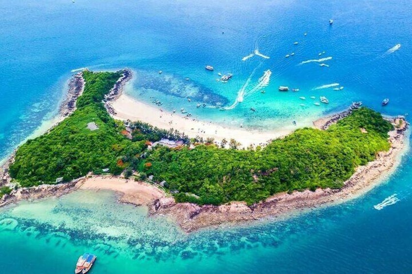 Une vue aérienne d’une île tropicale, avec ses eaux turquoise et limpides, sa plage de sable et sa végétation luxuriante. 2