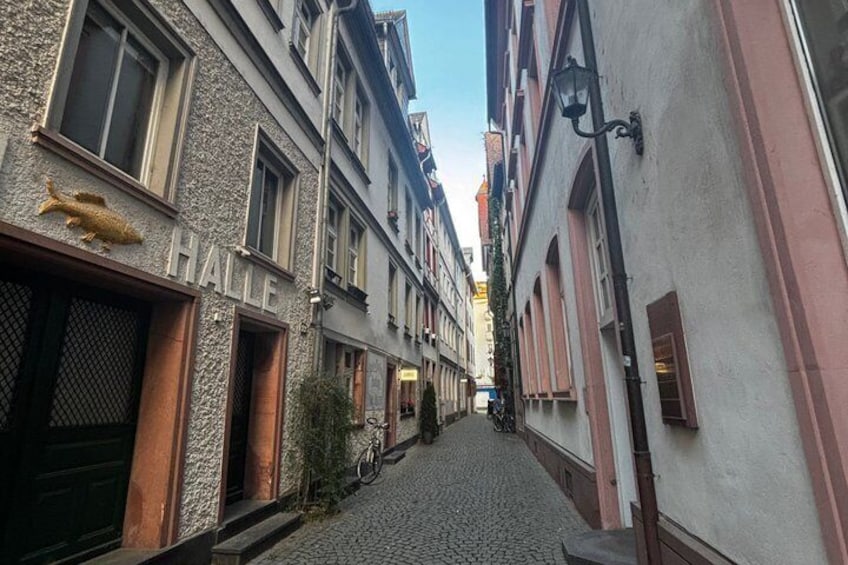 A cobblestone street lined with historic buildings, a bicycle, and a street lamp. 3