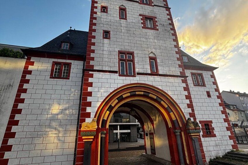 A building with a tower, red and white brickwork, and an arched entrance. 5