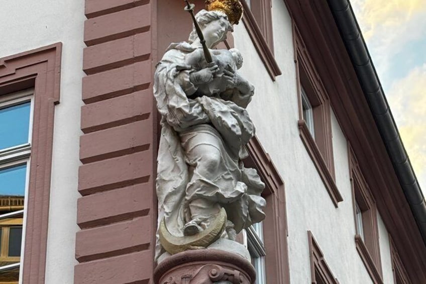 A statue of a woman holding a child on a building corner. 2