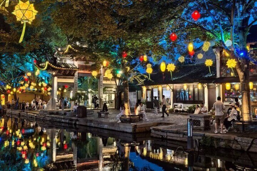 Een traditionele Chinese tuin 's nachts, met verlichte lantaarns en een rustig waterlichaam. 2