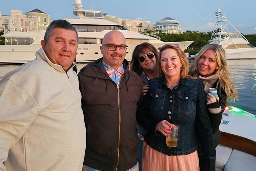 A group of people on a boat with yachts in the background. 3