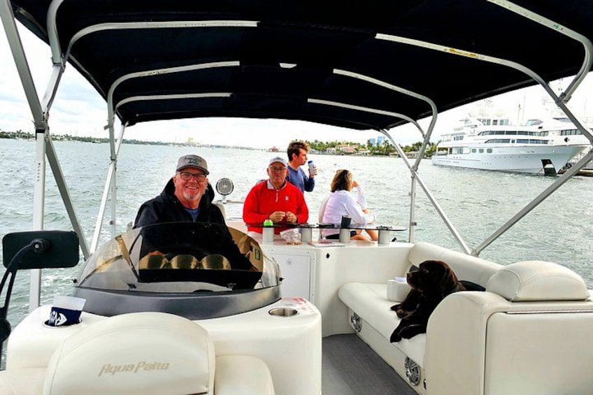 A boat with a covered seating area, a person driving, and another person sitting at the back. 3