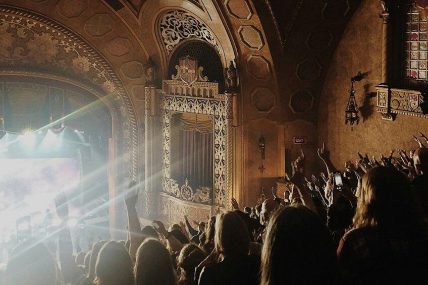 An ornate theater interior with a crowd of people. 3