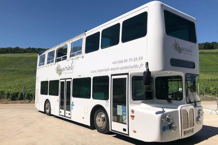 A white double-decker bus with 'Imperial' branding parked on a concrete surface. 5