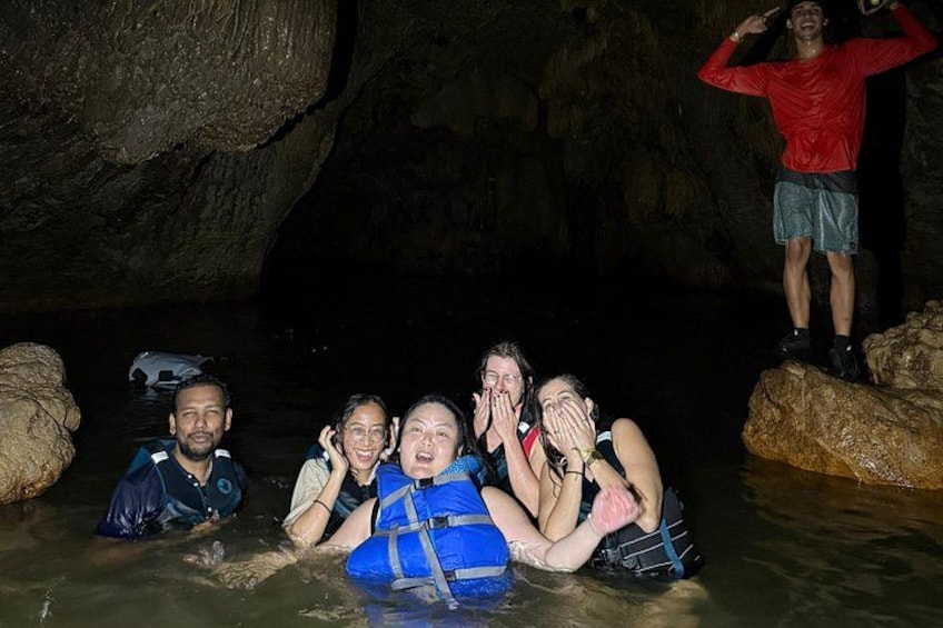 People in a cave with water, wearing life jackets. 4