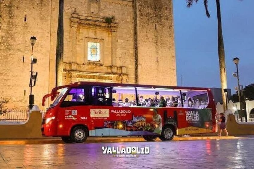 A red Turibus bus with 'VALLADOLID' and 'CITY TOUR' written on it, parked in front of a historic building. 4