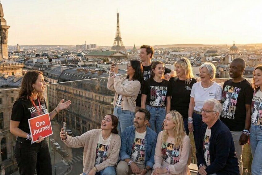 A group of people on a rooftop overlooking a cityscape with the Eiffel Tower in the background. 1