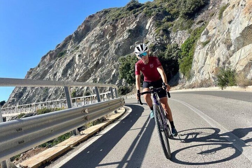 A cyclist on a road with a mountain backdrop. 3