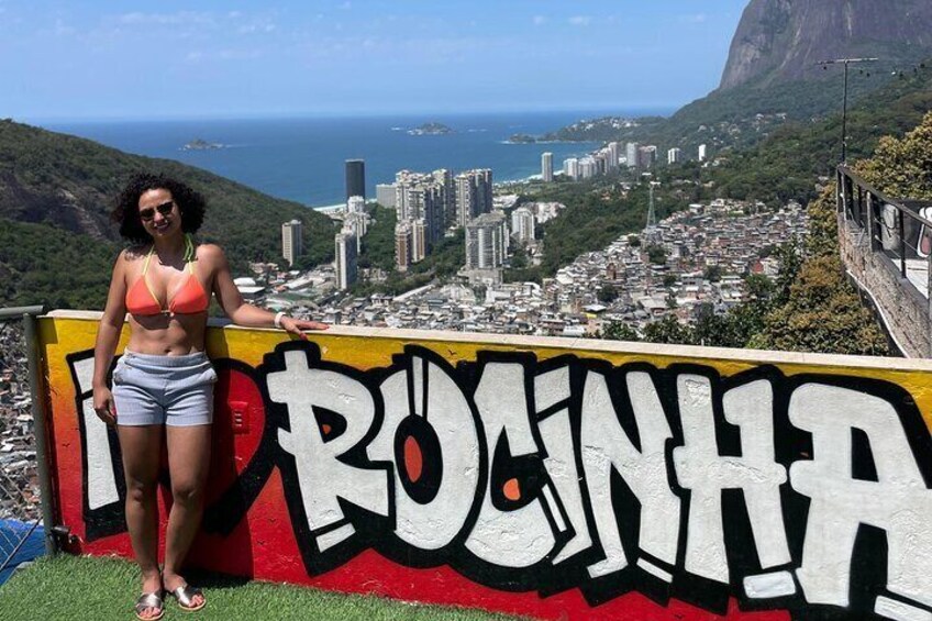 Une personne se tient devant un mur couvert de graffitis, sur lequel on peut apercevoir le mot « RIO ». 4