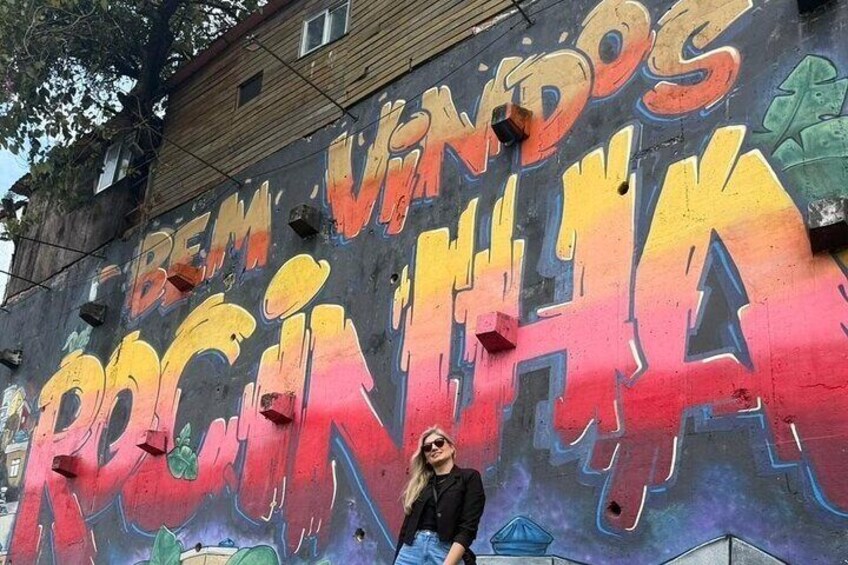 Une fresque murale colorée, réalisée à la bombe, avec les inscriptions « BEM VINDOS » et « ROGINHA ». 5