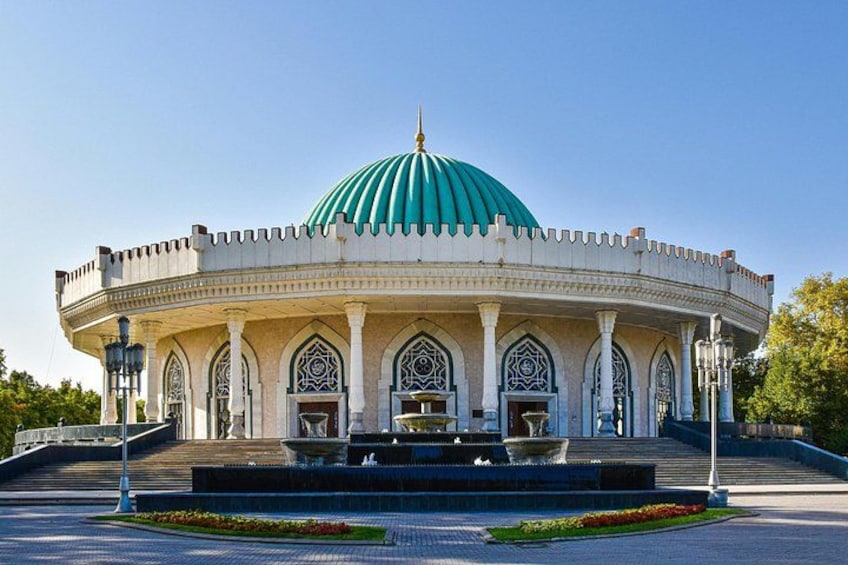 Un grande edificio a cupola con tetto verde, circondato da un'area paesaggistica con delle scale che vi conducono. 1