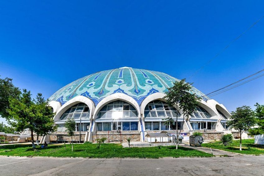 A large, domed building with intricate blue and white patterns, surrounded by a well-maintained lawn and a few trees. 4