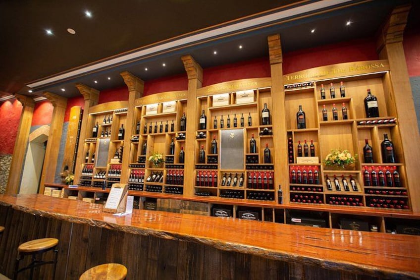 Un bar avec des étagères en bois remplies de bouteilles de vin. 1