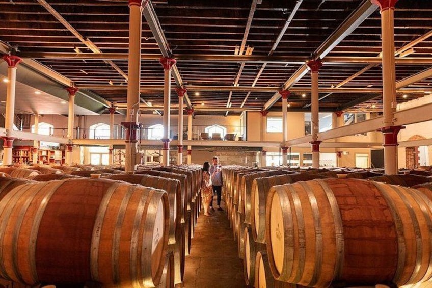 Une cave à vin avec des rangées de barriques en bois. 5