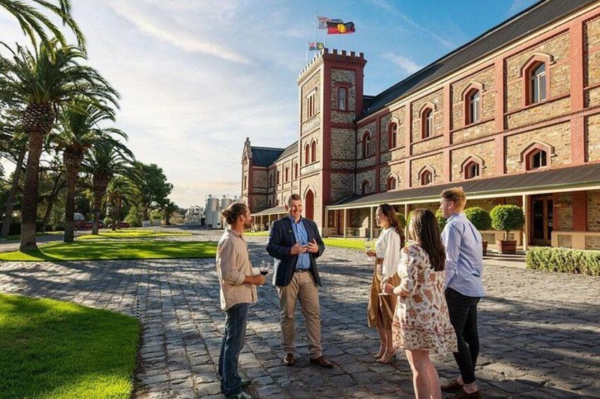 Un groupe de personnes se tient devant un bâtiment historique doté d’une tour avec une horloge. 1