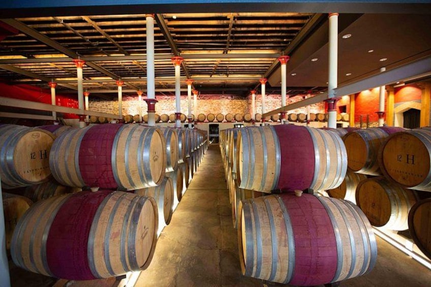 De nombreuses rangées de barriques en bois remplies de vin dans une cave. 3