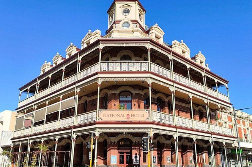 A historic building with multiple balconies and a clock tower, labeled as the National Hotel. 3