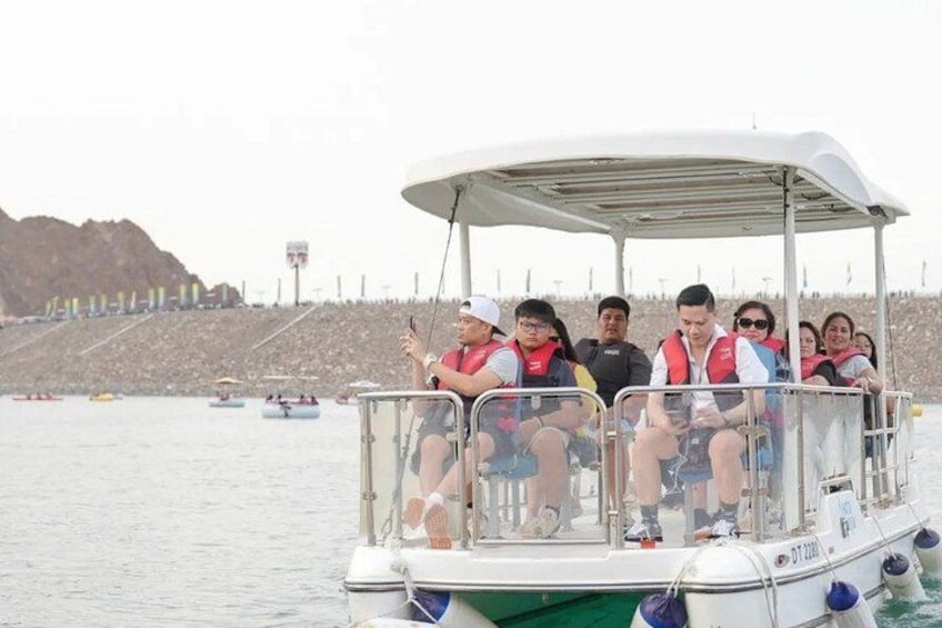 Un grupo de personas en un bote con una costa rocosa al fondo. 4