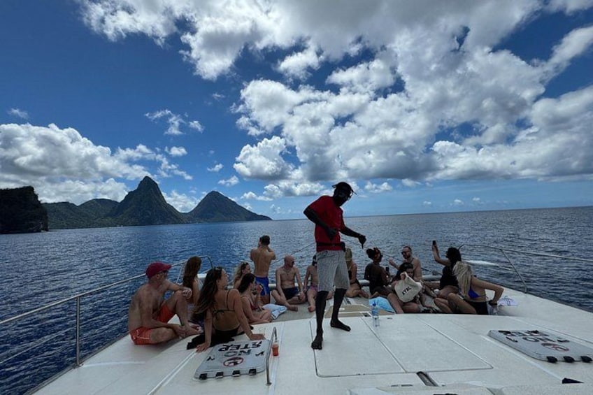 Eine Gruppe von Personen auf einem Boot vor einer gebirgigen Landschaft. 1