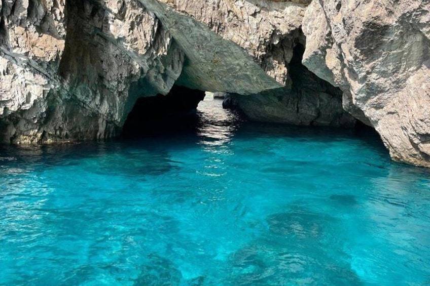 Ein klares, blaues Schwimmbecken unter einer Felsformation. 3
