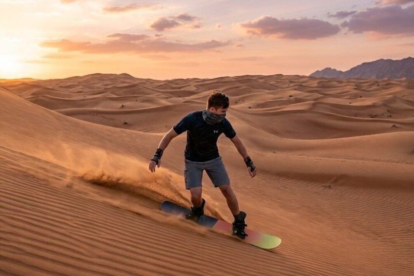 Een persoon snowboardend over een zandduin. 4