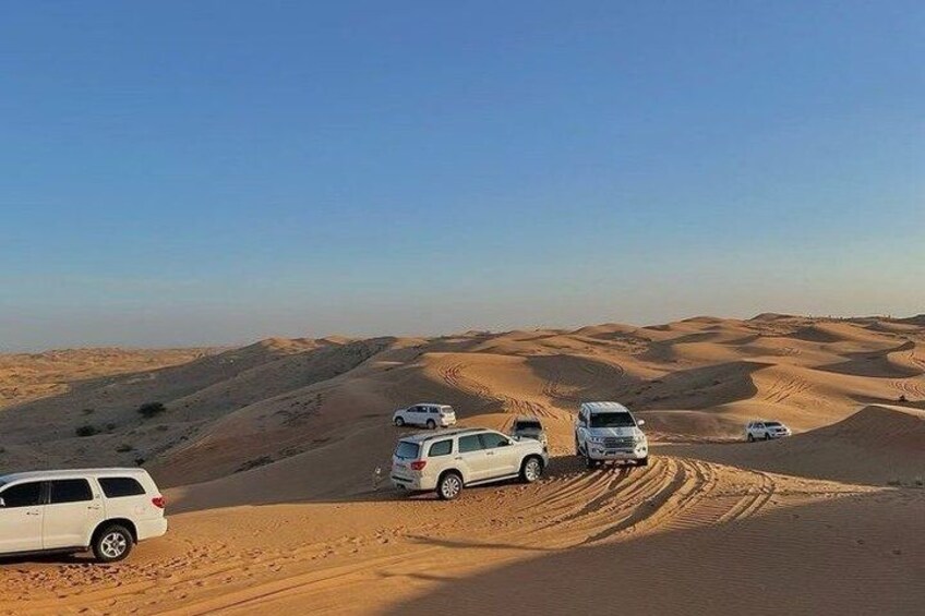 A desert landscape with sand dunes and vehicles. 4