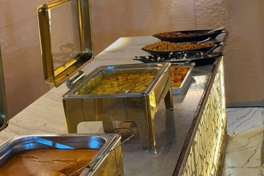 Ein Buffet mit verschiedenen Gerichten in Metallbehältern. 4