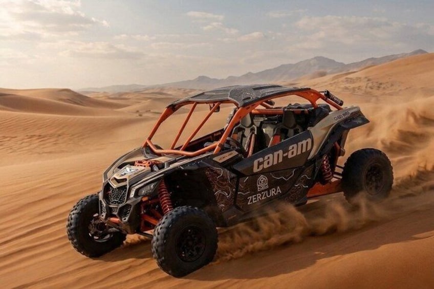 Een Can-Am rijdt door een woestijn met zandduinen. 3
