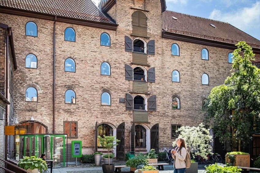 A historic brick building with arched windows and a courtyard with potted plants. 5