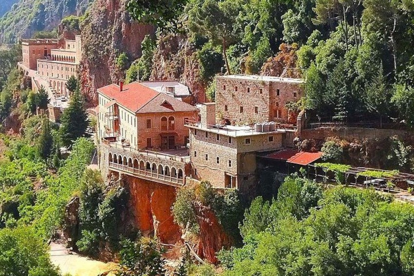 A castle perched on a cliff with lush greenery and a river below. 5
