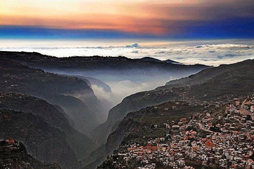 A valley with a town nestled at its base, surrounded by mountains. 4