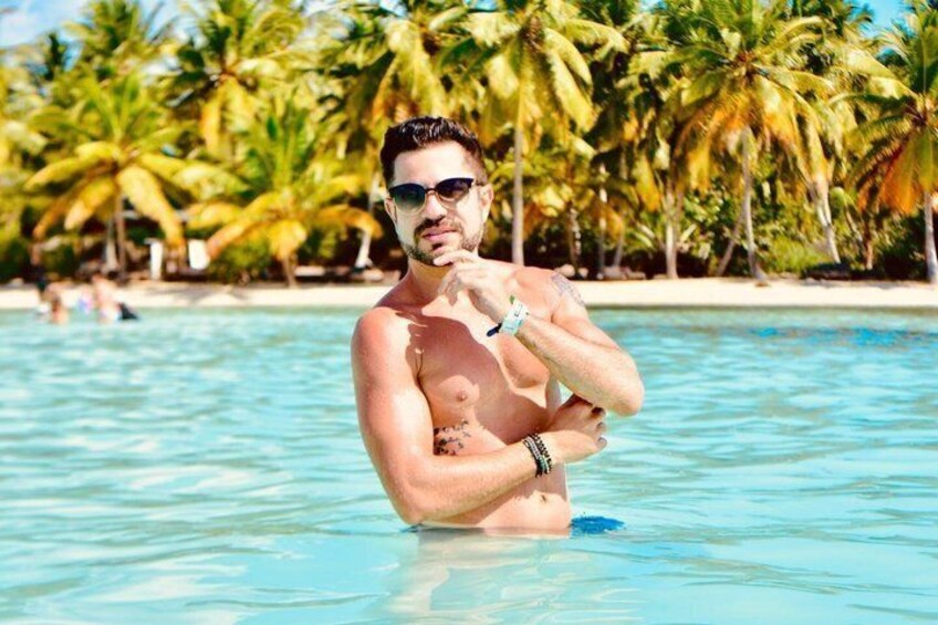 Une personne dans une piscine, avec des palmiers en arrière-plan. 2