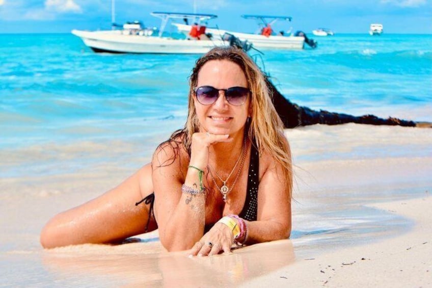 Une personne allongée sur une plage, avec des bateaux en arrière-plan. 4