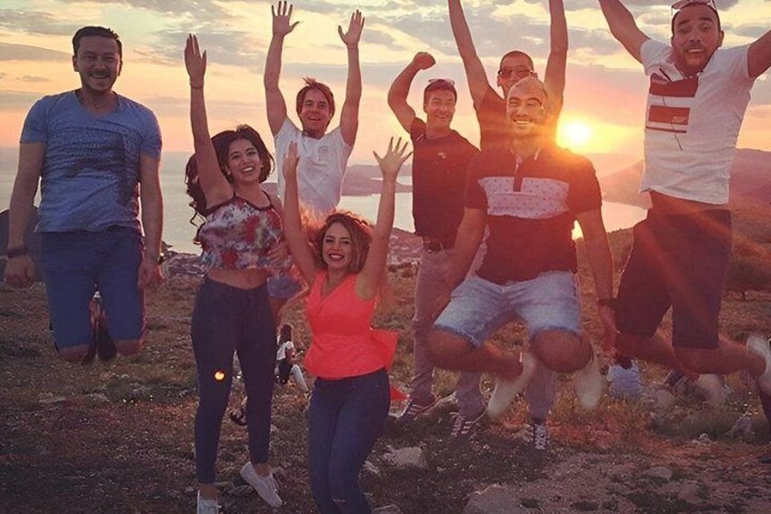 Eine Gruppe von Menschen springt bei Sonnenuntergang am Strand. 2