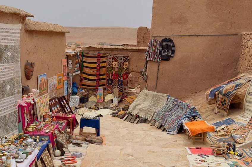 Un étal de marché proposant des textiles, des tapis et des objets de décoration. 5