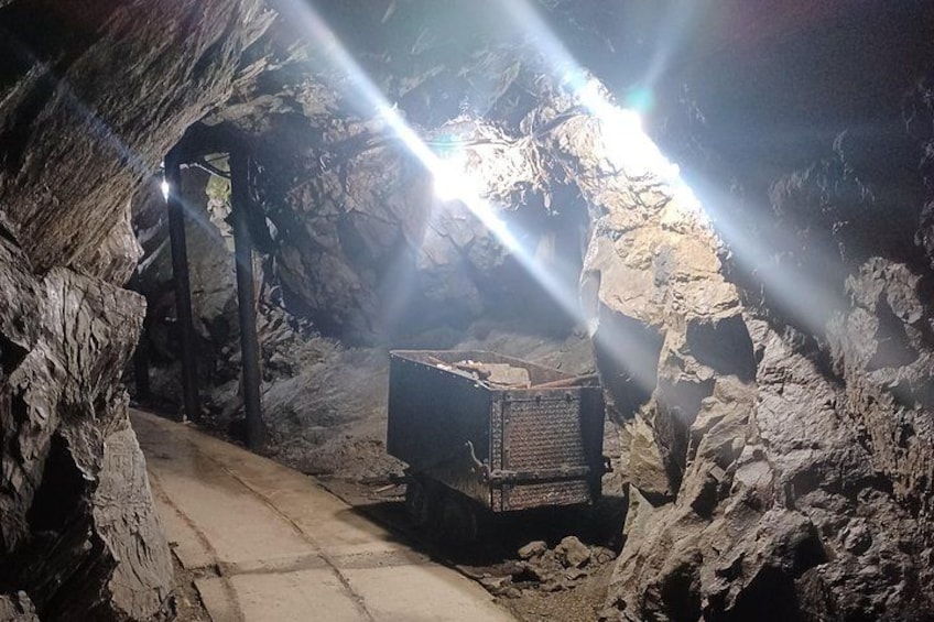 A cave with a metal container and a beam of light. 1