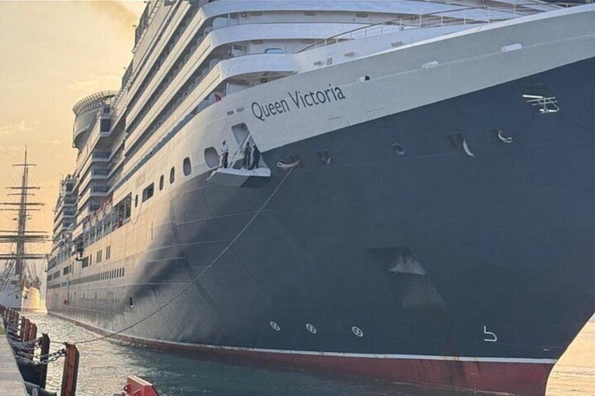 A large cruise ship named Queen Victoria docked at a port. 2