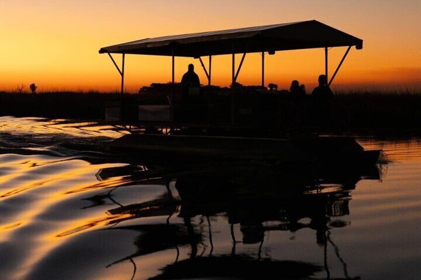 Ein Boot mit Personen bei Sonnenuntergang. 1