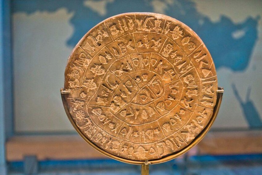 A circular artifact with intricate engravings and text, displayed on a stand. 2