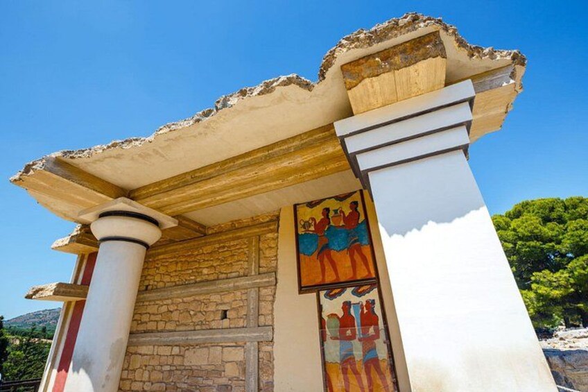 Un edificio con fachada de piedra, techo de tejas y un mural colorido. 3