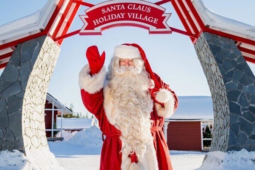 Weihnachtsmann vor einem Schild mit der Aufschrift 'Santa Claus Holiday Village'. 2