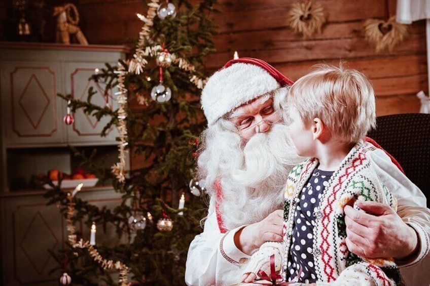 Eine Person im Weihnachtsmannkostüm umarmt ein Kind. 1
