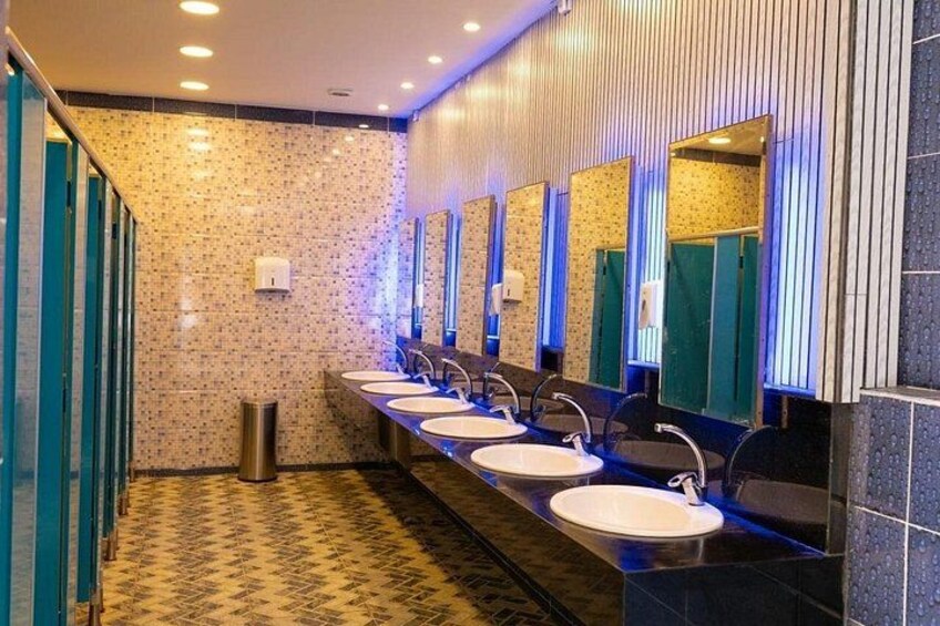 Des toilettes publiques dotées de plusieurs lavabos, de miroirs et d’un sol à motifs. 2
