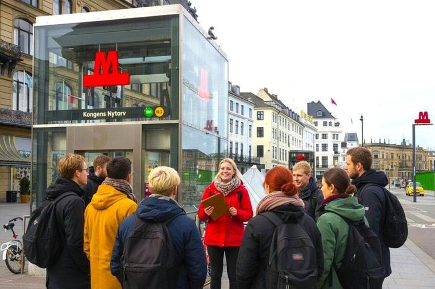 Eine Gruppe von Menschen steht vor einem Gebäude mit einem großen roten 'M'-Schild. 5